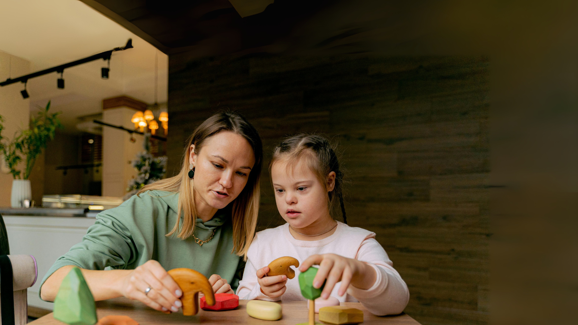 Mum and Daughter sat at table playing with toys